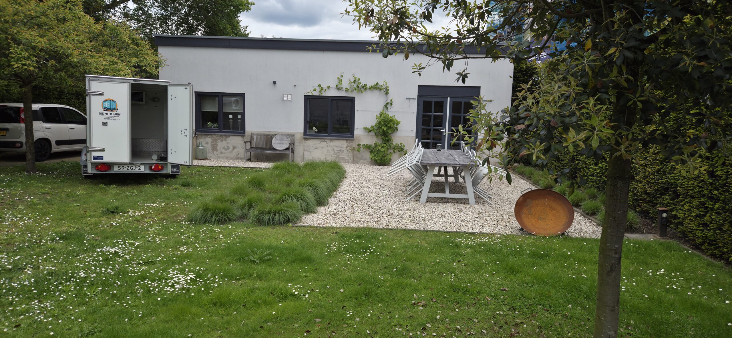 Koelaanhanger van Nie Meer Lauw in een tuin, klaar voor een feest